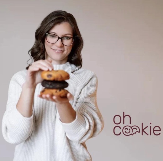 Eine Frau stapelt frische Cookies als leckere Mitarbeiterverpflegung von Schrankerl.