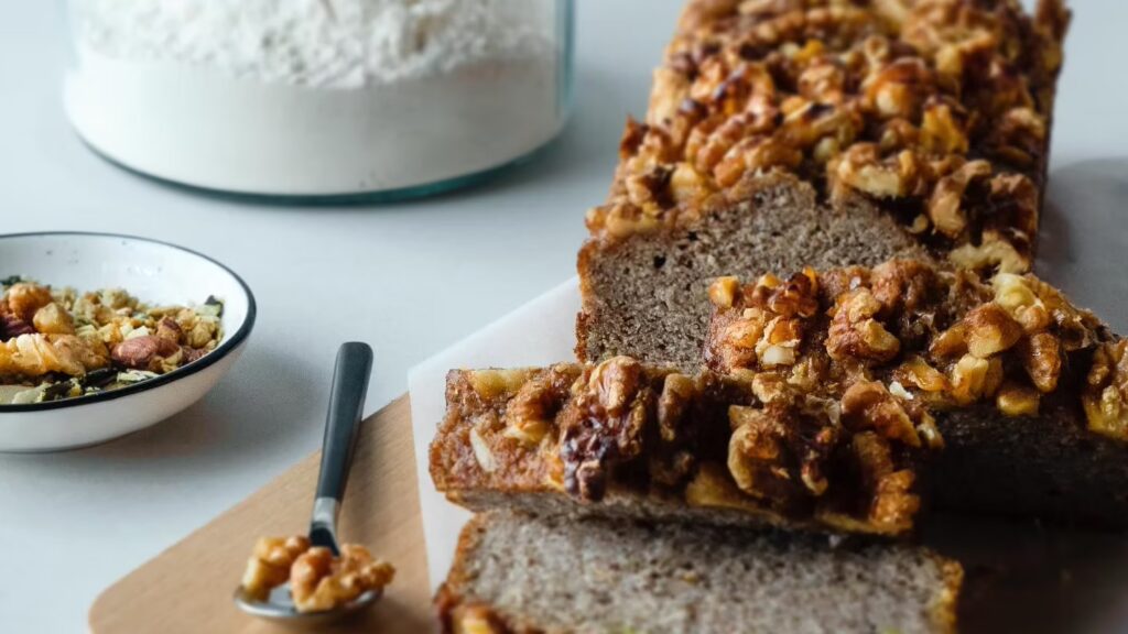 Frisch gebackenes Nussbrot mit Walnüssen als gesunde Mitarbeiterverpflegung auf einem Holzbrett.