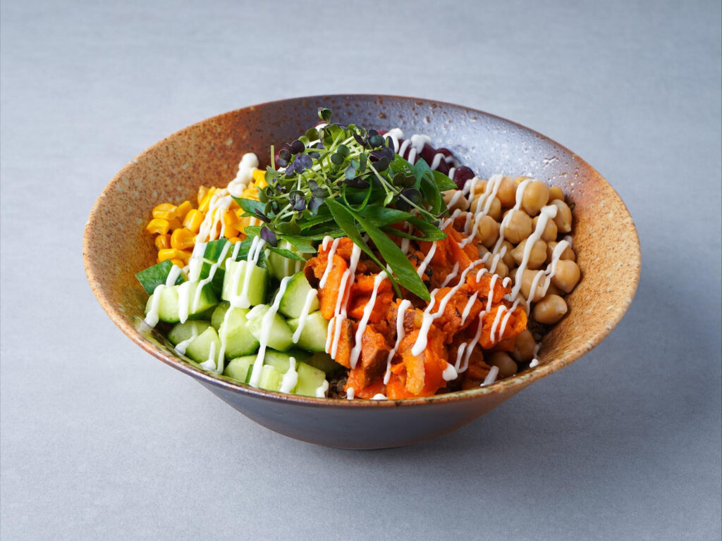 Frische Bowl zur gesunden Mitarbeiterverpflegung von Schrankerl mit Süßkartoffeln, Gurken und Kichererbsen.