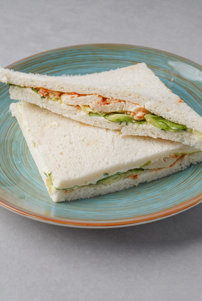 Frisches Hähnchen-Sandwich auf einem blauen Teller für eine ausgewogene Mitarbeiterverpflegung von Schrankerl.