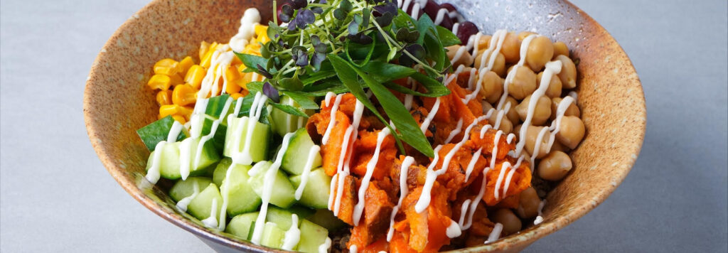 Gesunde Bowl mit Süßkartoffeln, Kichererbsen und frischem Gemüse für eine ausgewogene Mitarbeiterverpflegung.