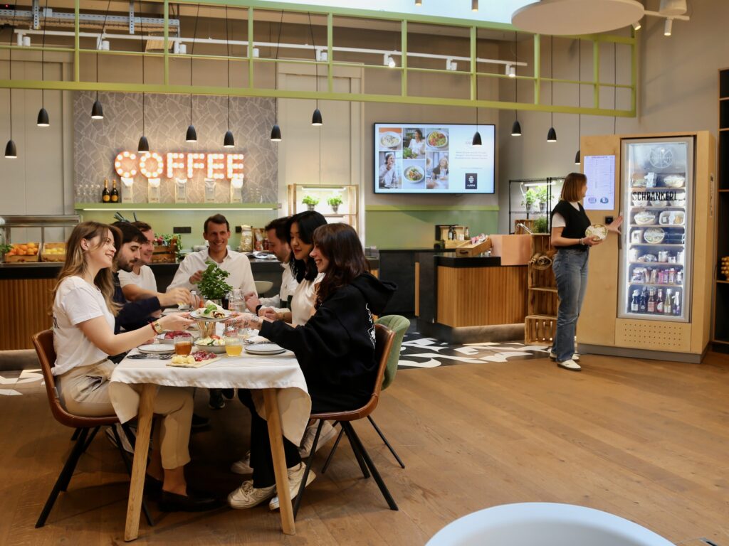 Kolleginnen und Kollegen beim gemeinsamen Mittagessen mit moderner Mitarbeiterverpflegung von Schrankerl.