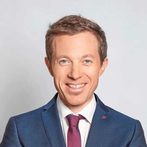 Lächelnder Mann im blauen Anzug als Experte für moderne Mitarbeiterverpflegung.